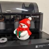 Người tuyết ôm hộp quà xanh nơ đỏ in 3D nhiều màu